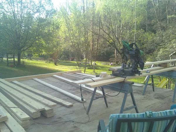 Miter saw and framing lumber on a deck under construction in Johnston