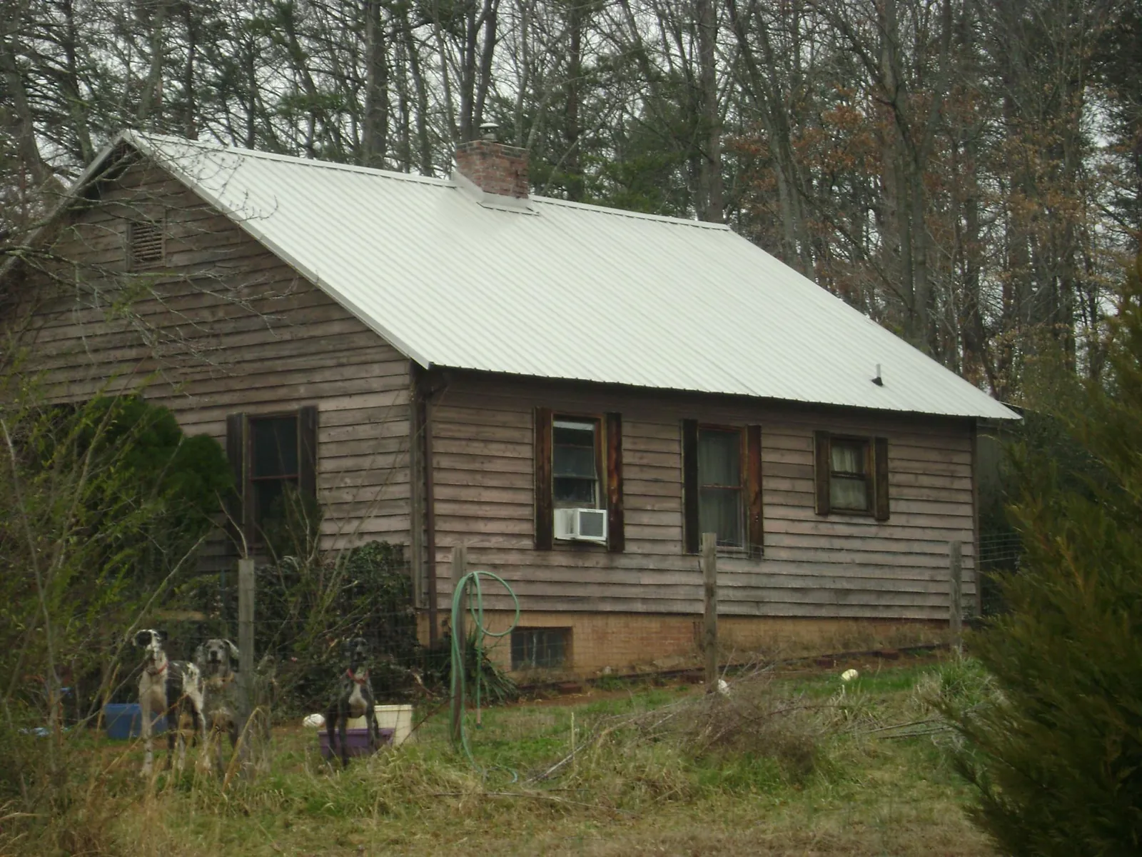 White metal roof on an old wood sided farmhouse, from a Asphalt Shingle Roof Repair job in Johnston